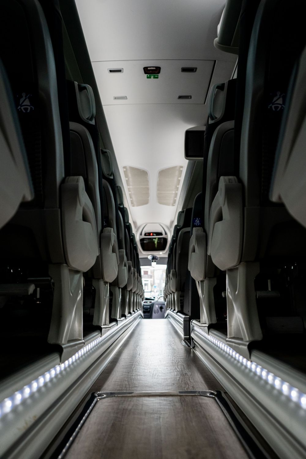 Long corridor view of luxury vehicle interior with LED floor lighting.