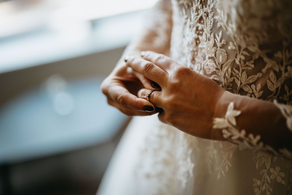 De ring, een belangrijk familie erfstuk voor deze bruid, wordt om haar vinger geschoven