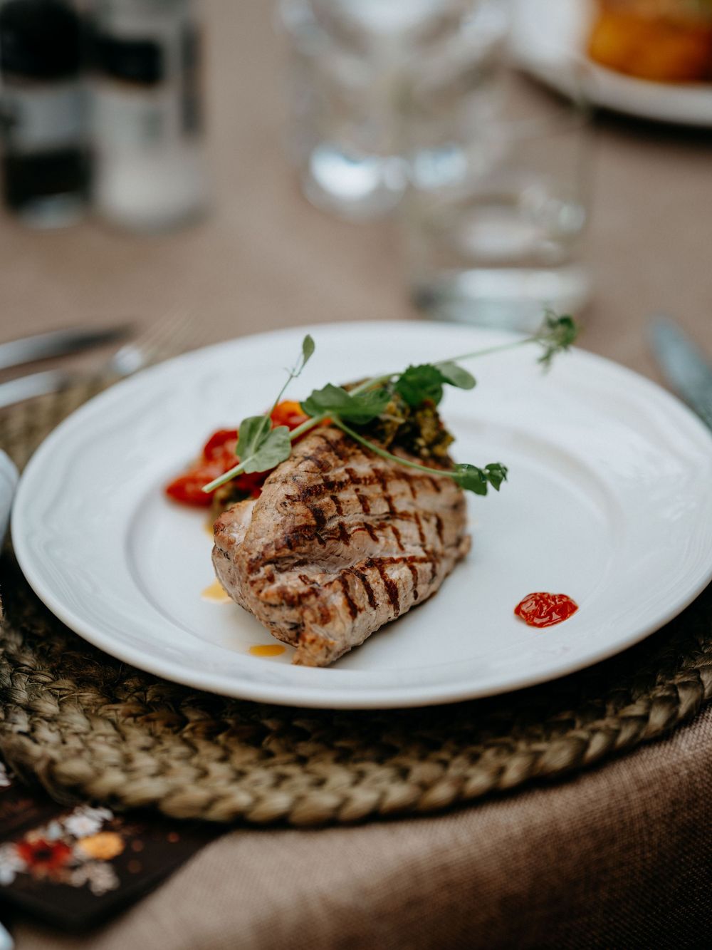 Tijdens het trouw-diner wordt een heerlijk stuk vlees op een mooie manier gepresenteerd op een bord.