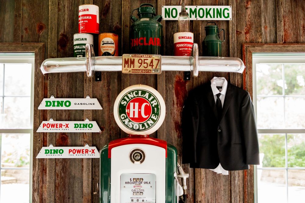 Vintage signs and memorabilia decorate a rustic wooden wall in an old-fashioned establishment.