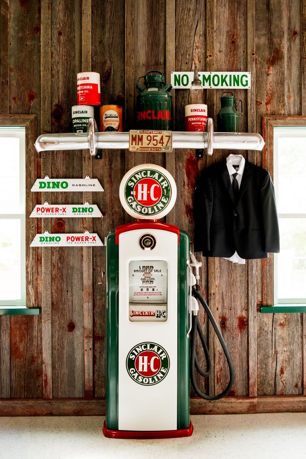 Vintage gas station display with Sinclair pumps and no smoking signs against rustic wooden wall.