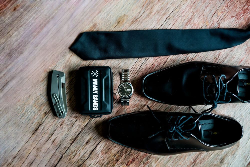 Close-up series of black dress shoes being put on against a wooden floor background.