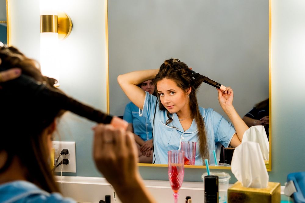 Wedding preparation scene with styling tools and beauty products on a vanity.