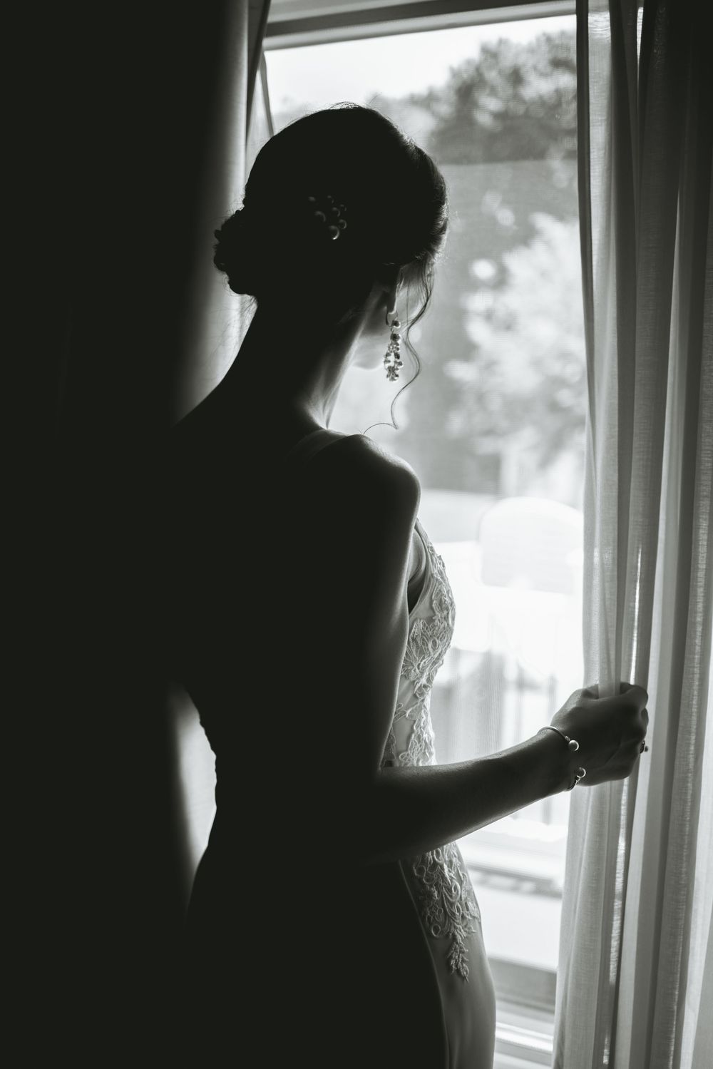 Silhouette of a person against a bright window with soft natural lighting.