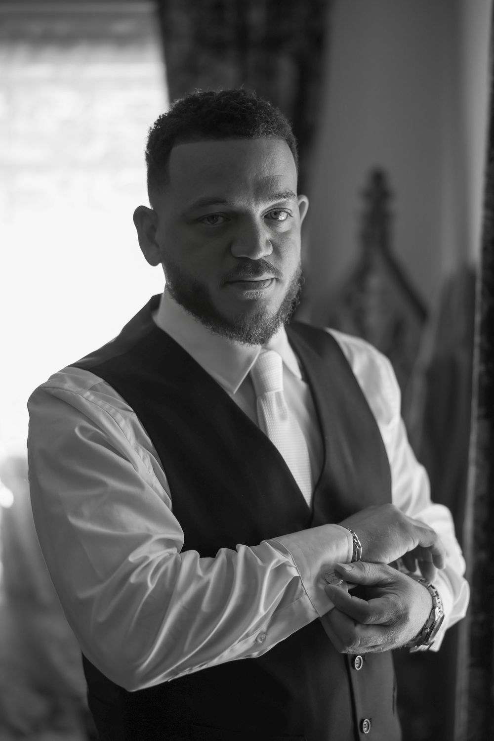 Man in formal attire adjusting his tie in a sequence of black and white photos.