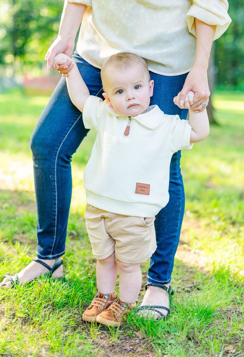 mama helping son walk during a family session