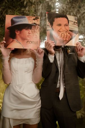 Wedding couple sharing a playful moment drinking from their glasses during the reception celebration.