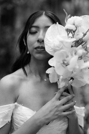 A series of dreamy black and white photographs showing someone in white delicately interacting with elegant white orchids.