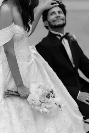 A black and white wedding photo series showing intimate moments between a bride in white dress and groom in dark suit.