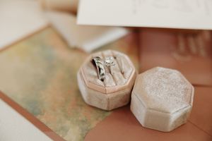 Small white ceramic bowls filled with salt and spices arranged on a rustic wooden surface.