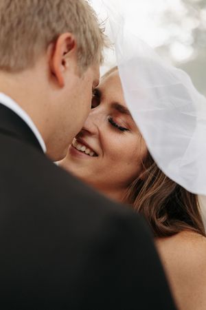 A romantic close-up of a bride and groom sharing an intimate kiss during their wedding celebration.