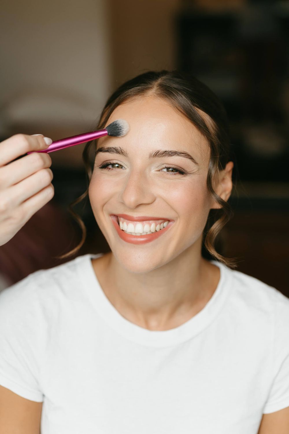Sequence of makeup application shots showing mascara and eye makeup being applied in a bright indoor setting.