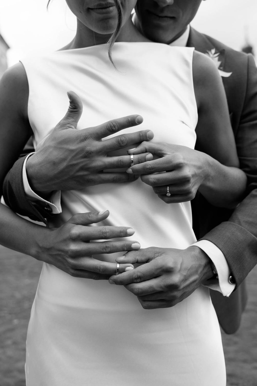 Black and white photo series showing close-up shots of hands embracing around a white dress in an intimate moment.