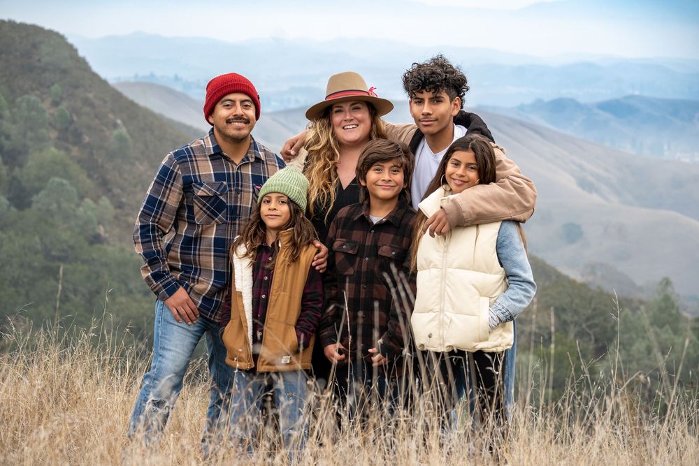 Friends enjoying outdoor adventure in mountain setting wearing casual winter attire.