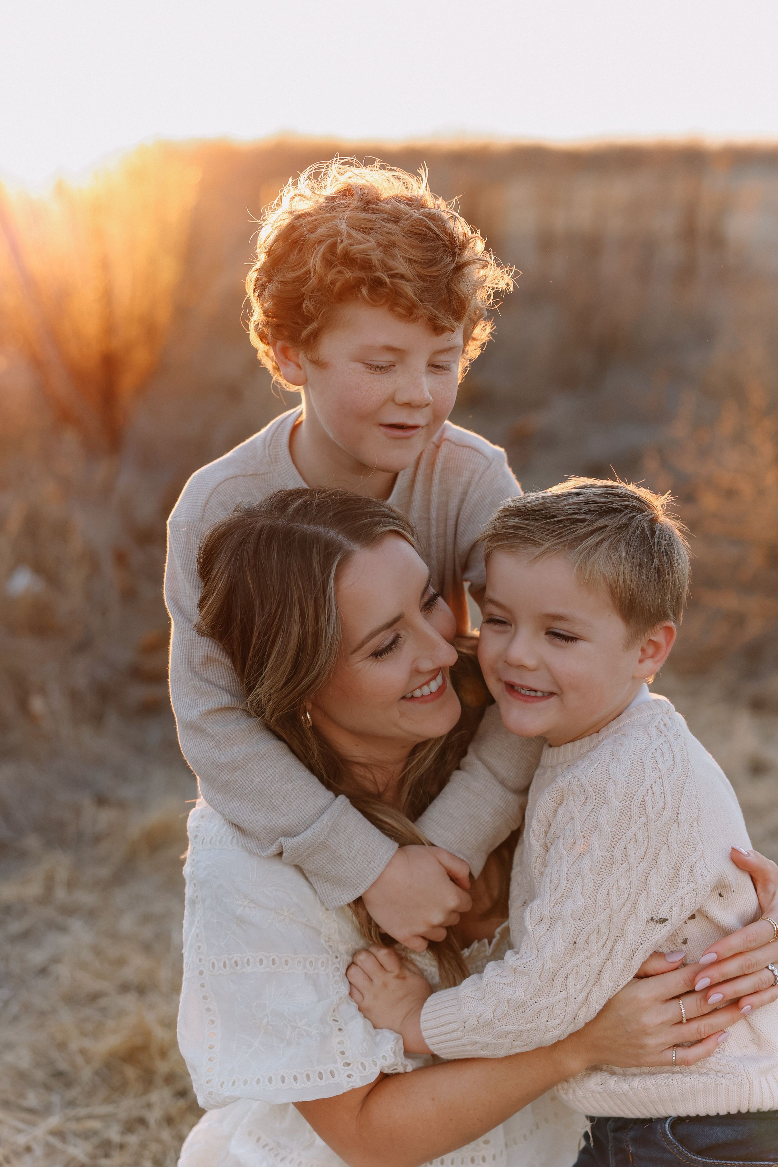 A warm family moment captured in warm golden sunlight during a sunset family photo session outdoors in California