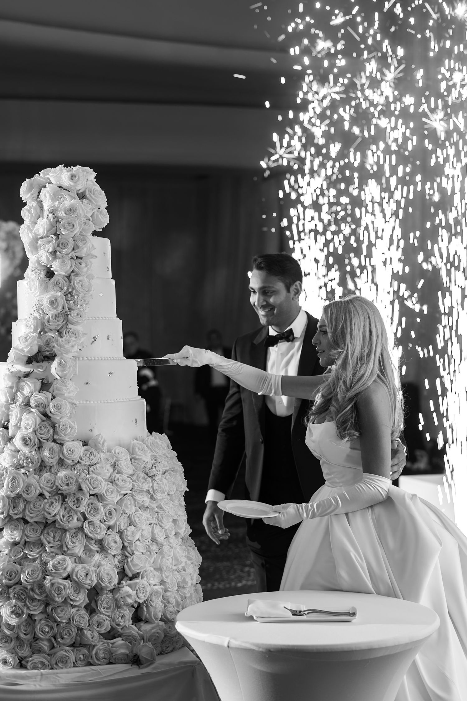 Luxury wedding at Fontainebleau in Miami, Florida.  Next-level cake cut, with fireworks behind couple.