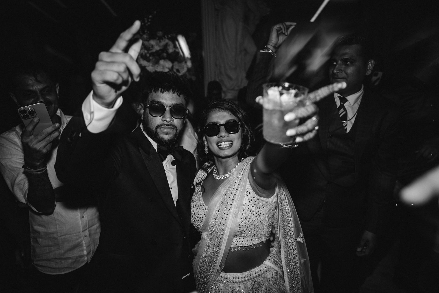Black and white photograph of a crowd dancing and celebrating at what appears to be a party or nightclub.