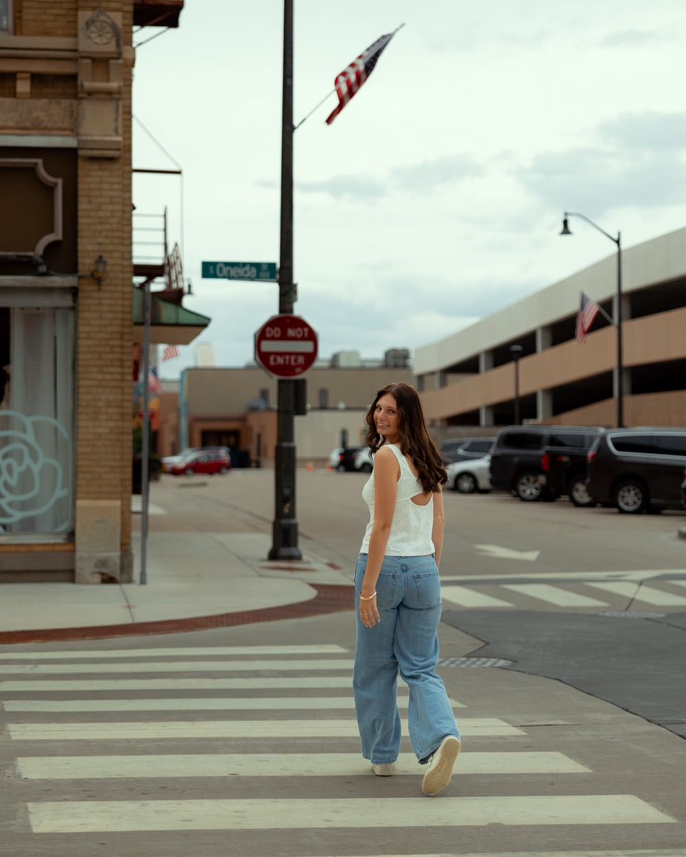 A sequence of photos showing a person in denim overalls walking across a crosswalk in an urban setting.