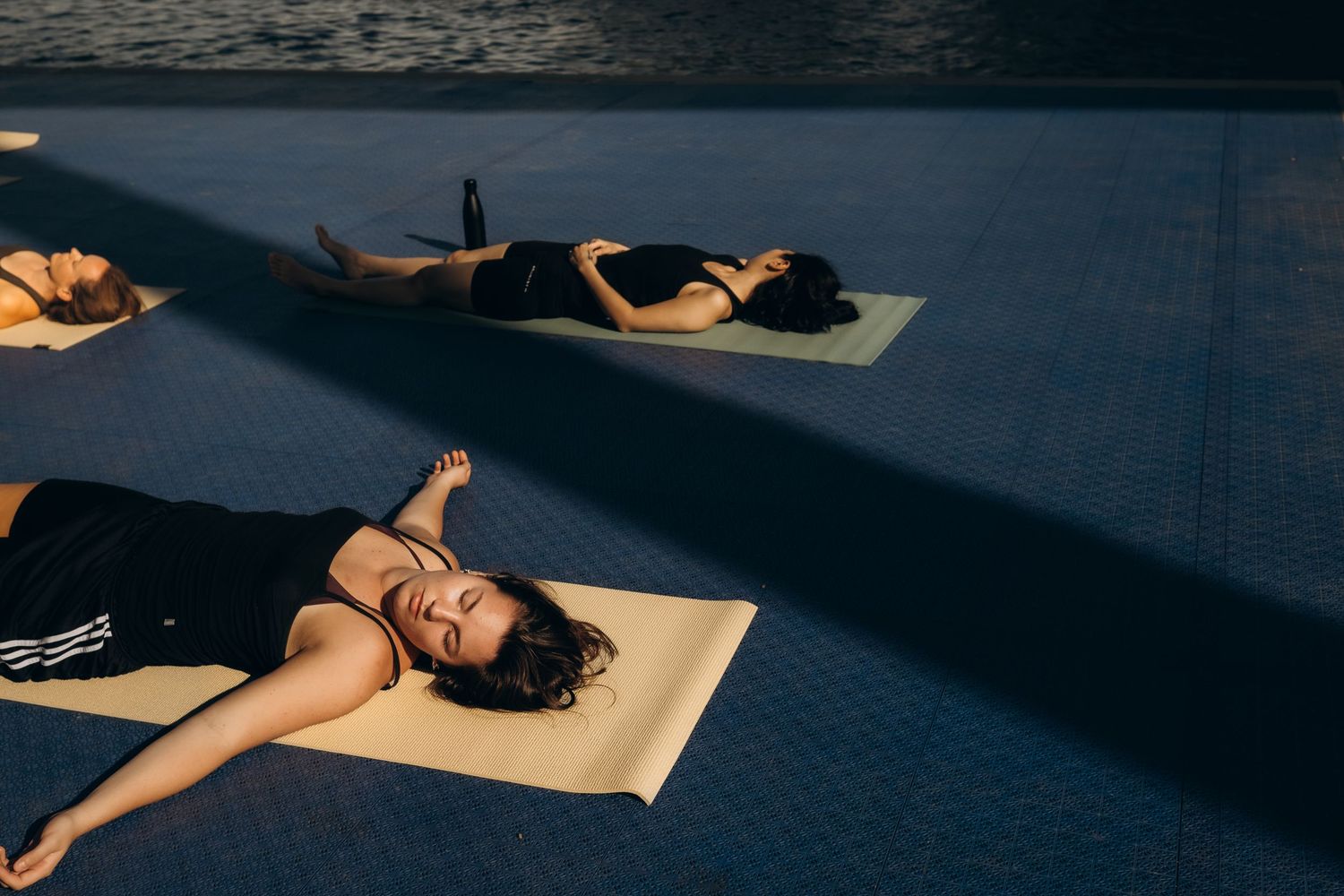 women lying on yoga mats after brand yoga session while being captured by yoga photographer in Stockholm