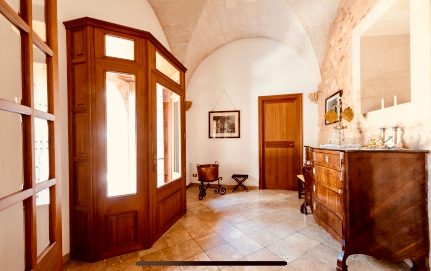 A panoramic view of a rustic wooden cabin interior with white walls and multiple windows letting in natural light.