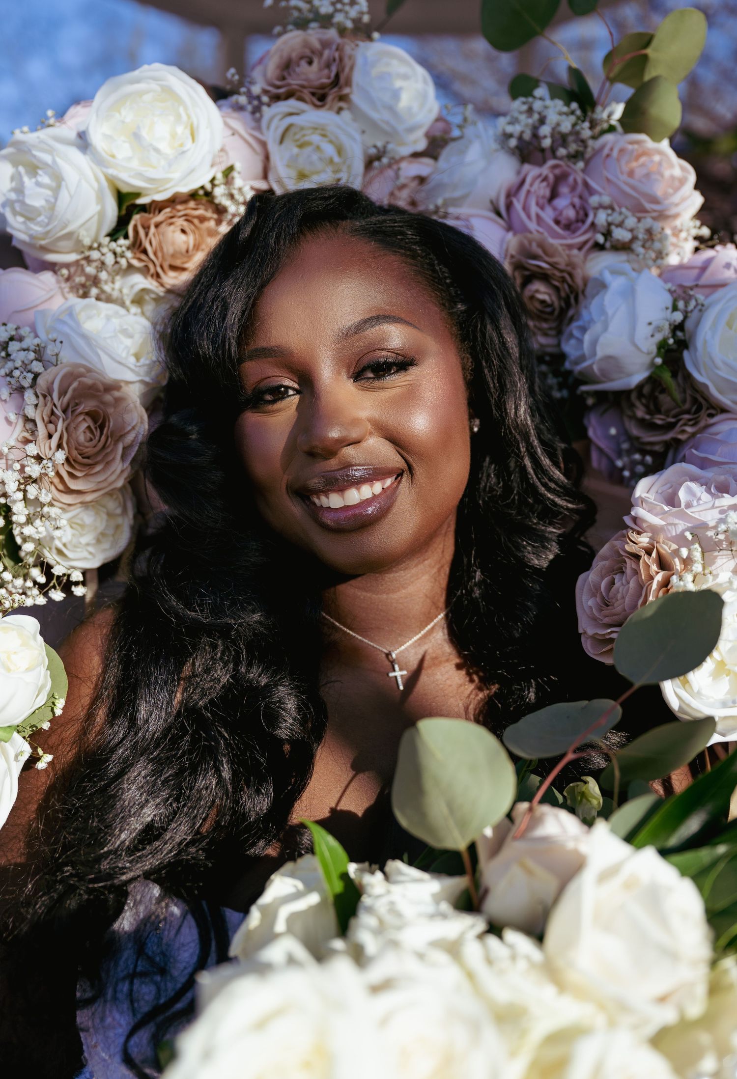A bridal portrait with delicate white and pink roses framing the elegant composition.