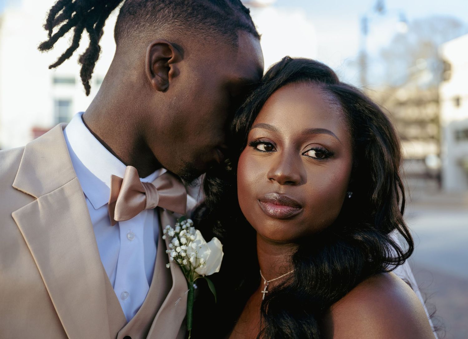 An intimate wedding portrait featuring a couple in cream and white attire.