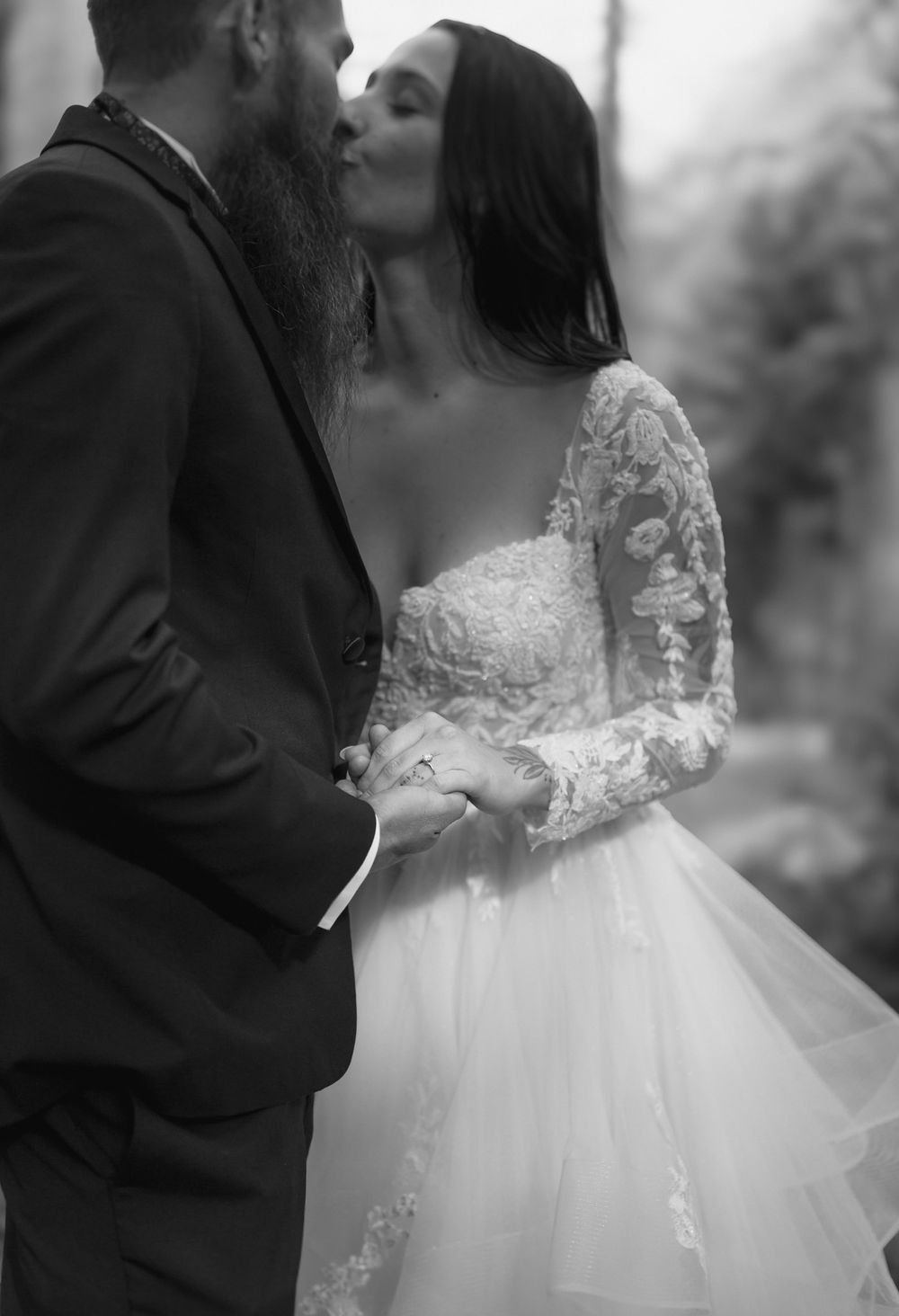 Romantic black and white wedding photo of couple kissing in lace gown and suit. Elopement wedding photography