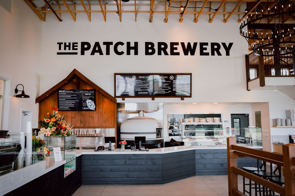 Modern industrial-style interior of The Patch Brewery with minimalist counter and wood accents.