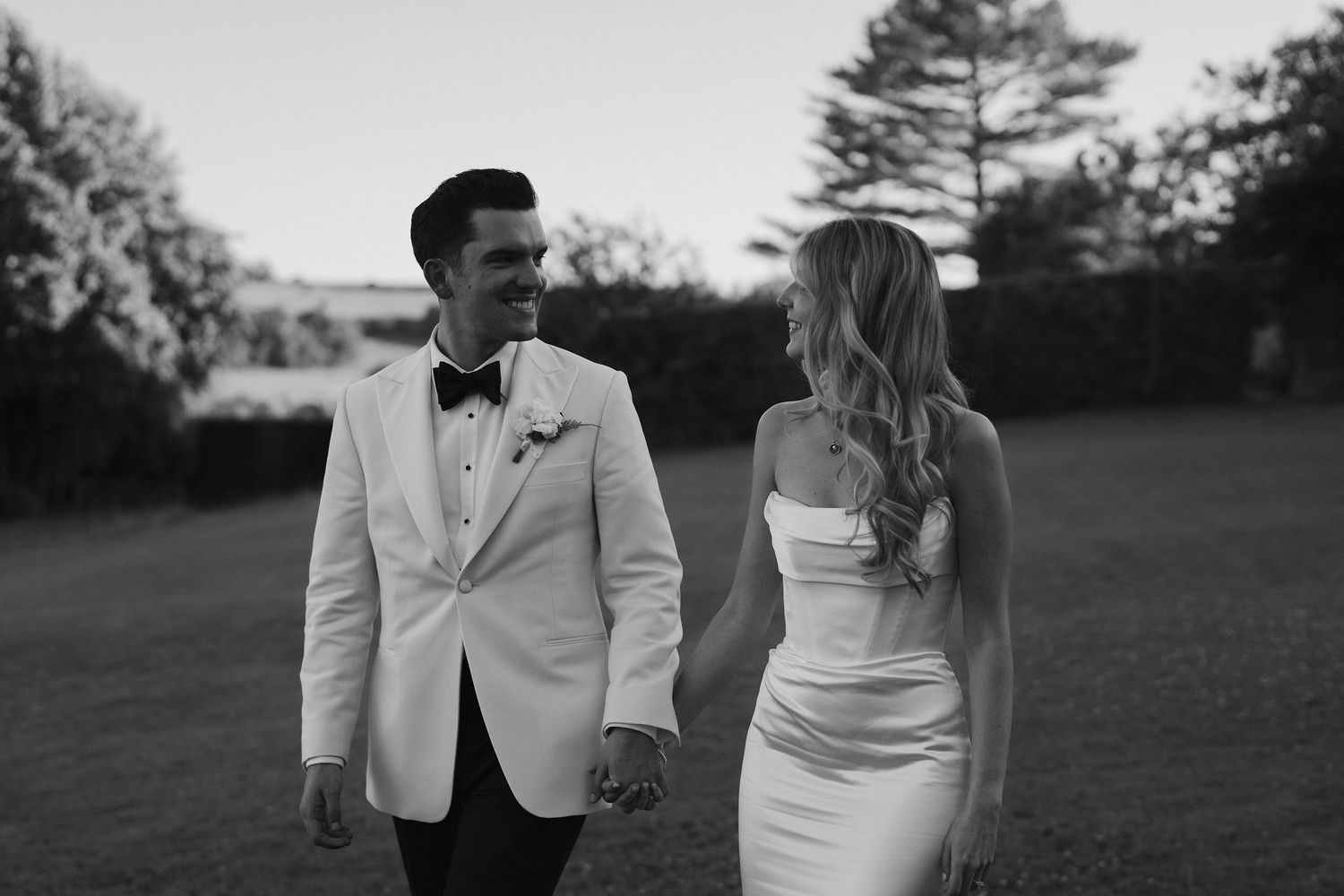 bride and groom smiling at each other while walking at hamswell house wedding in bath