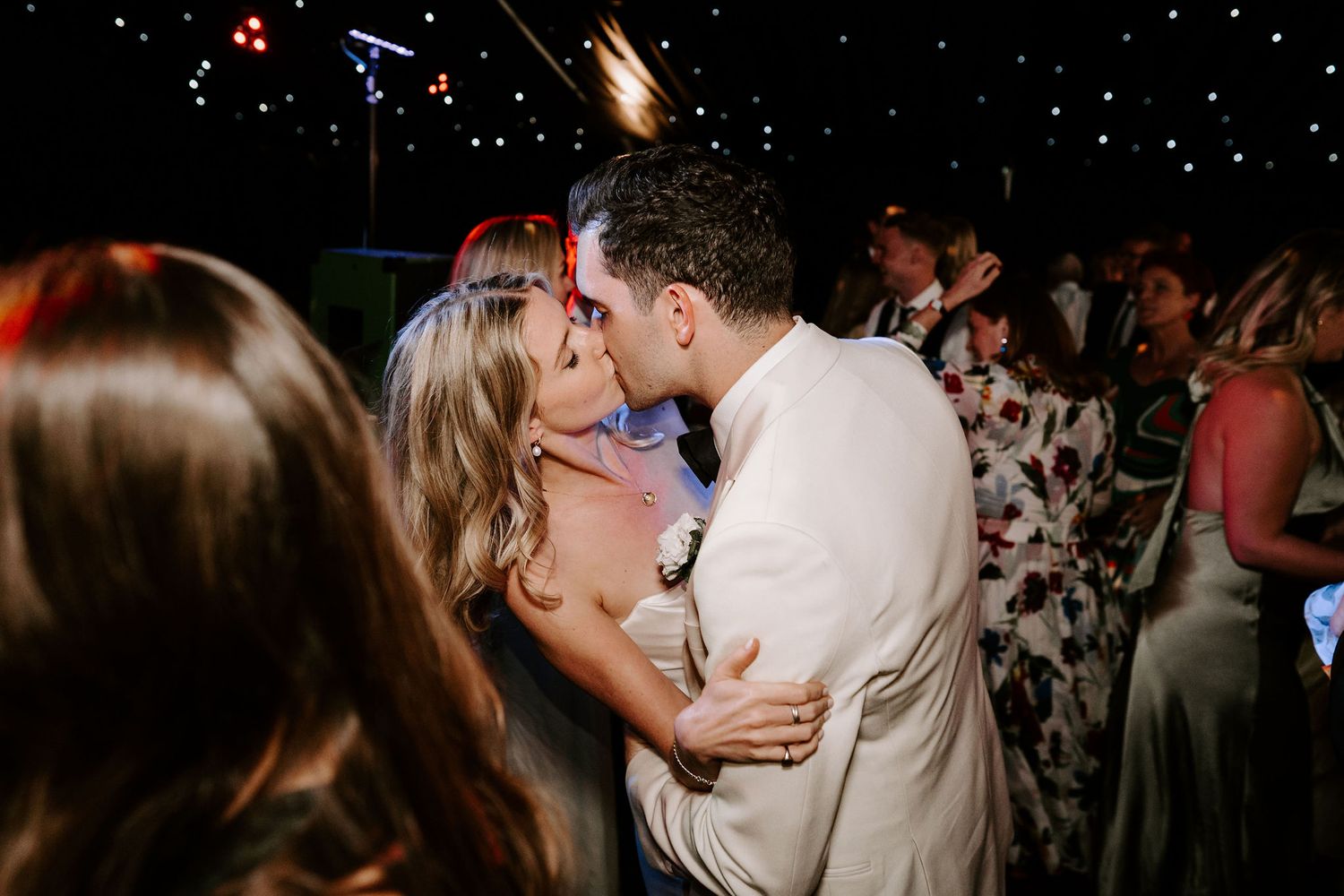 bride and groom kissing surrounded by their guests on the dance floor at hamswell house wedding in bath