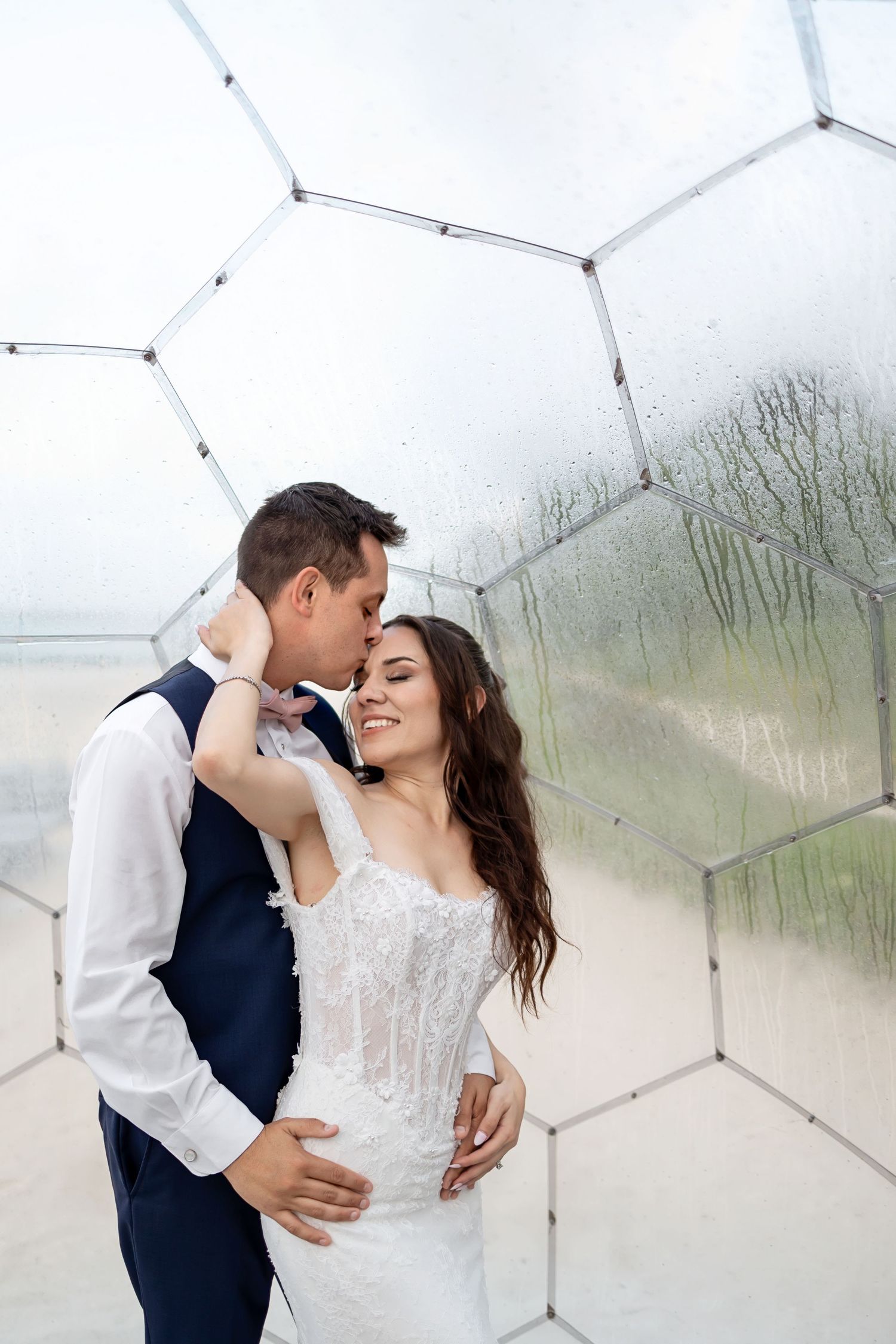 A wedding ceremony taking place outdoors at a waterfront venue with scenic views of a lighthouse and blue sky.