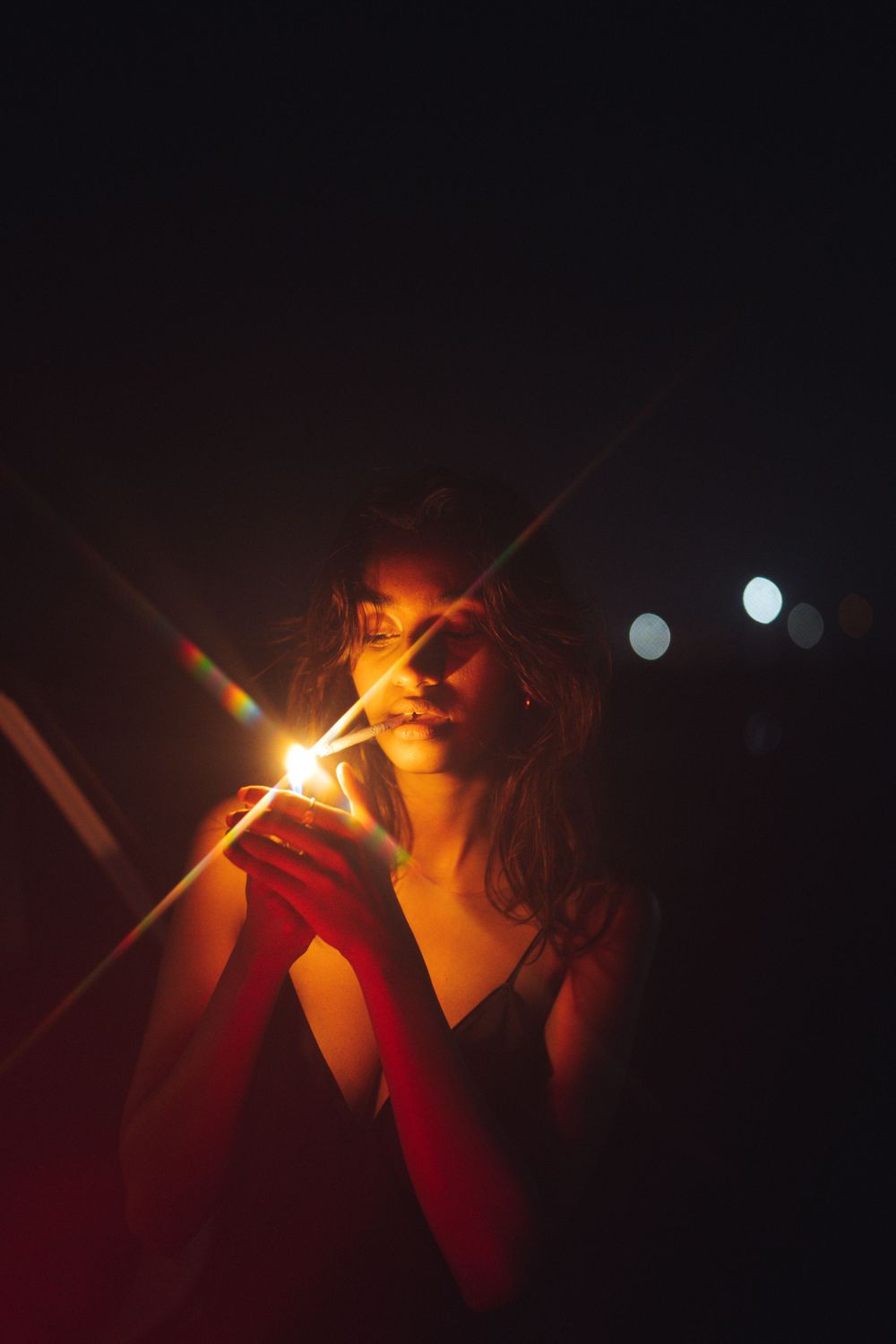 Atmospheric night photo with dramatic red lighting and lens flares in dark setting.