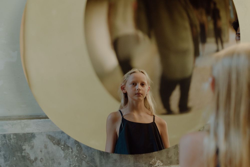 A mirror reflection creates an artistic double image effect in a modern interior setting.