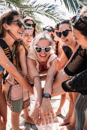 Joyful gathering under palm trees with friends in beachwear.