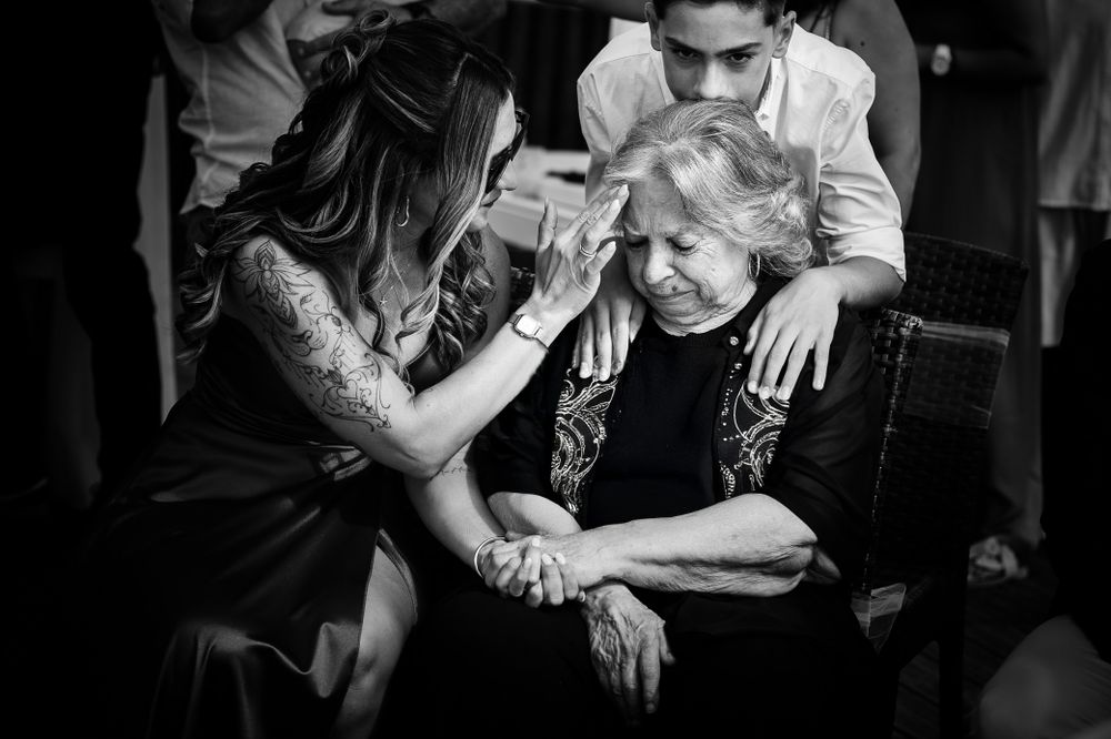 Black and white photograph showing a tender care moment happening in a sitting area.