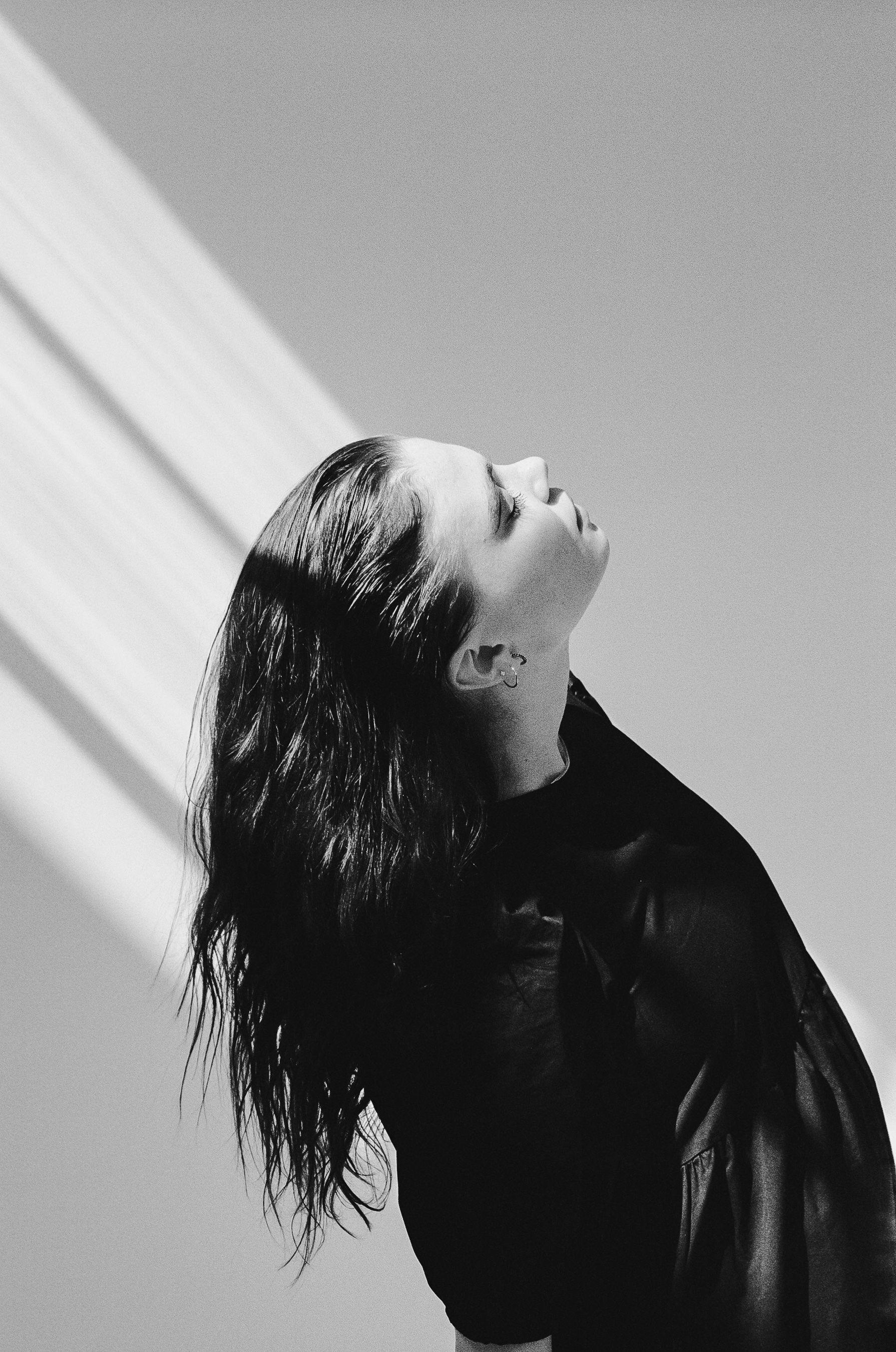 Dramatic black and white profile portrait showing shadow play from window light.