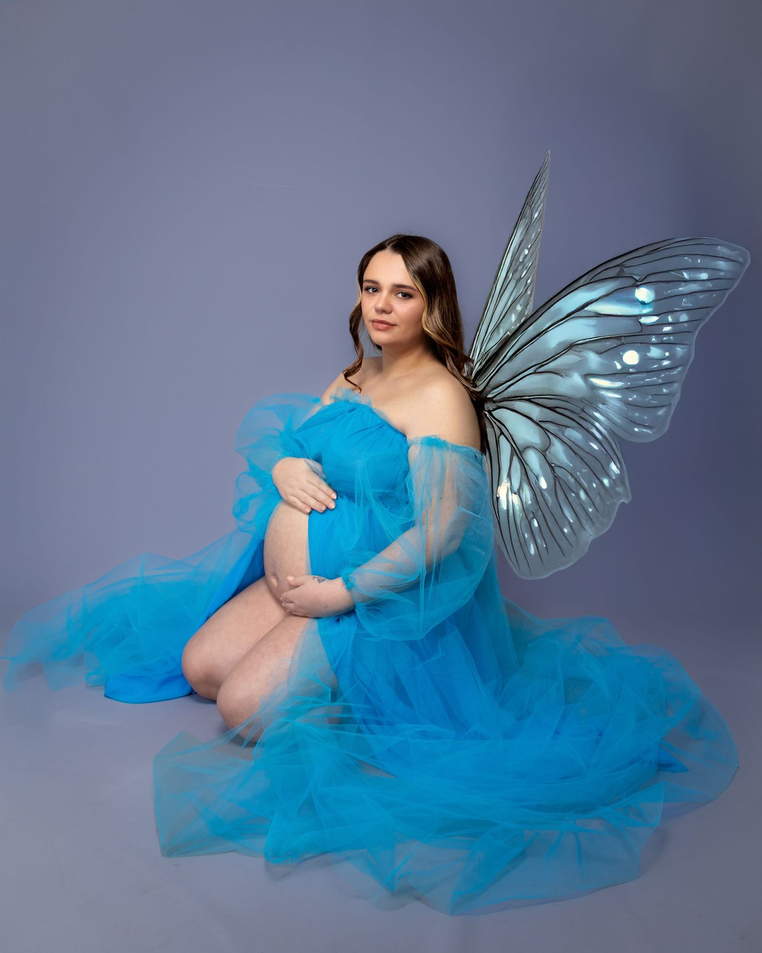 Ethereal maternity portrait with blue butterfly wings and sheer flowing dress. Best female maternity photographer