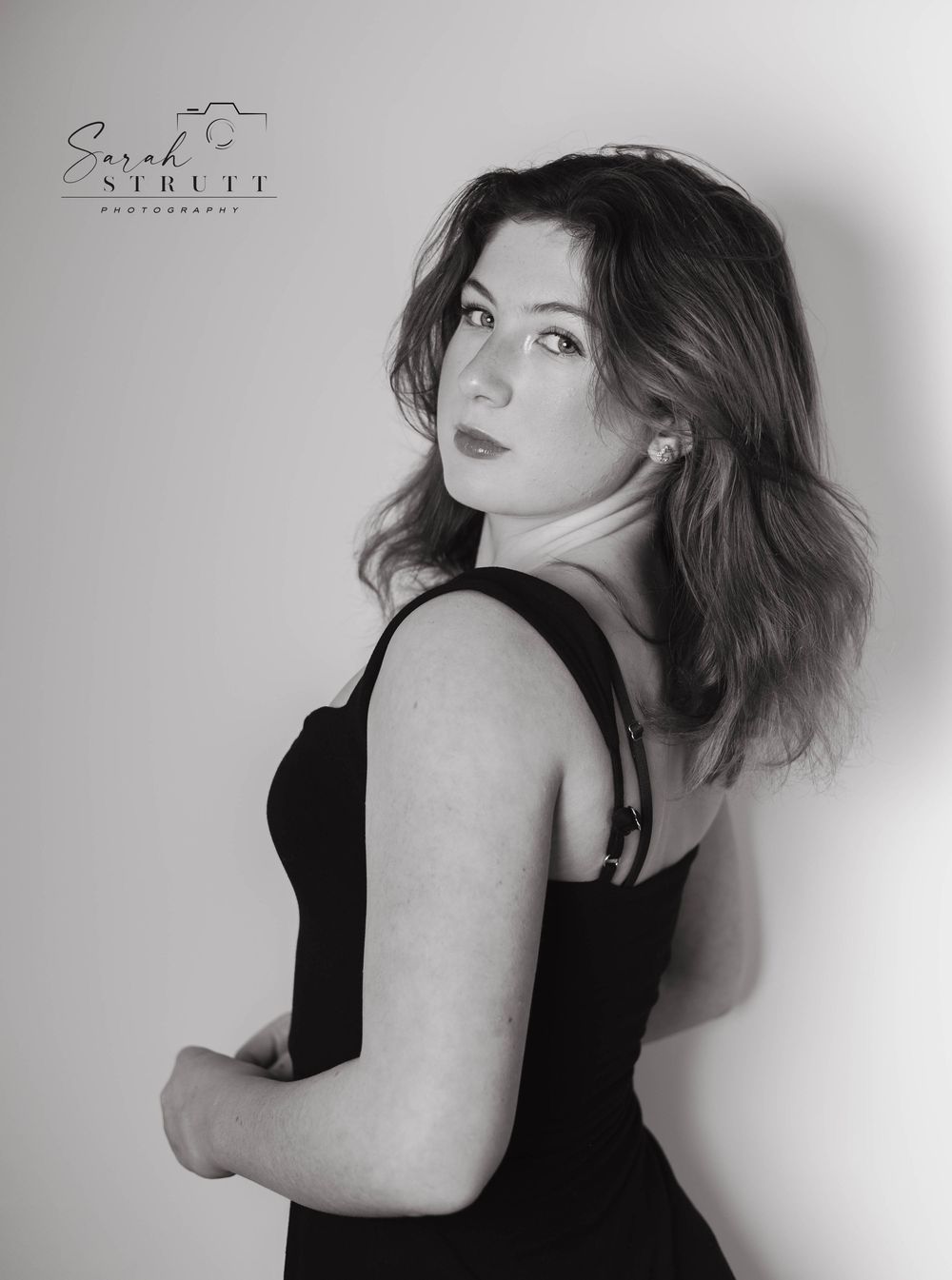 Artistic black and white portrait series showing graceful poses of a figure in a black sleeveless top against a light background.