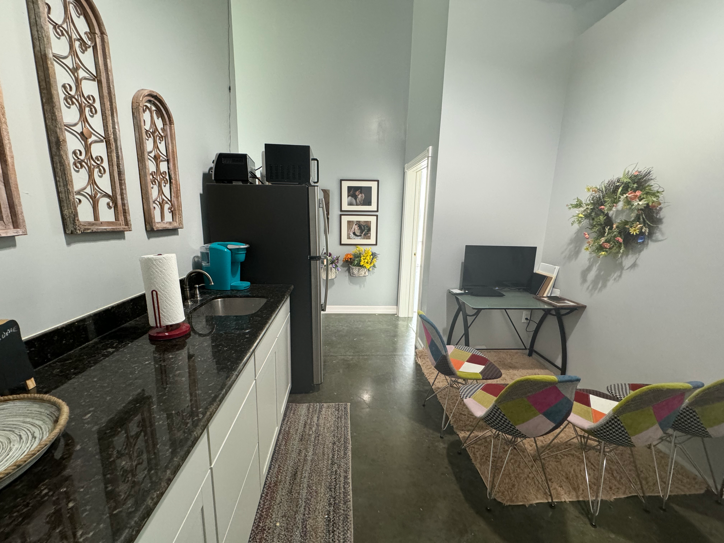 Modern studio space with dark countertops, decorative wall art, and comfortable lounge area.
