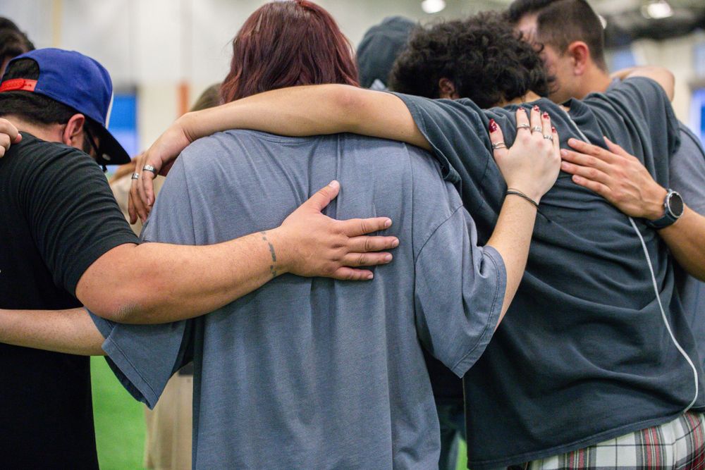 People embracing and showing support for each other in a line formation.