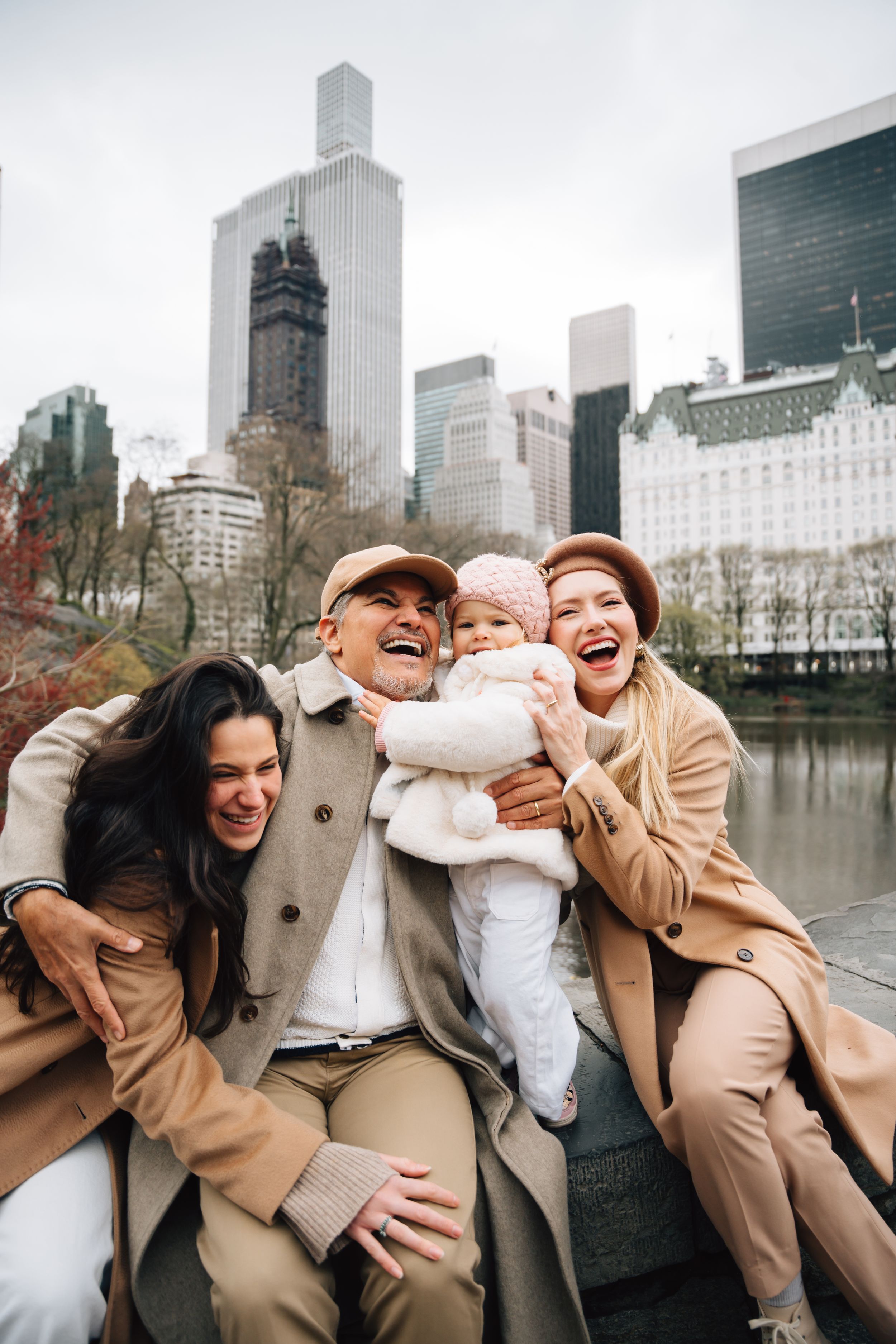 Group enjoys a joyful moment together near Central Park with the iconic New York City skyline in the background.