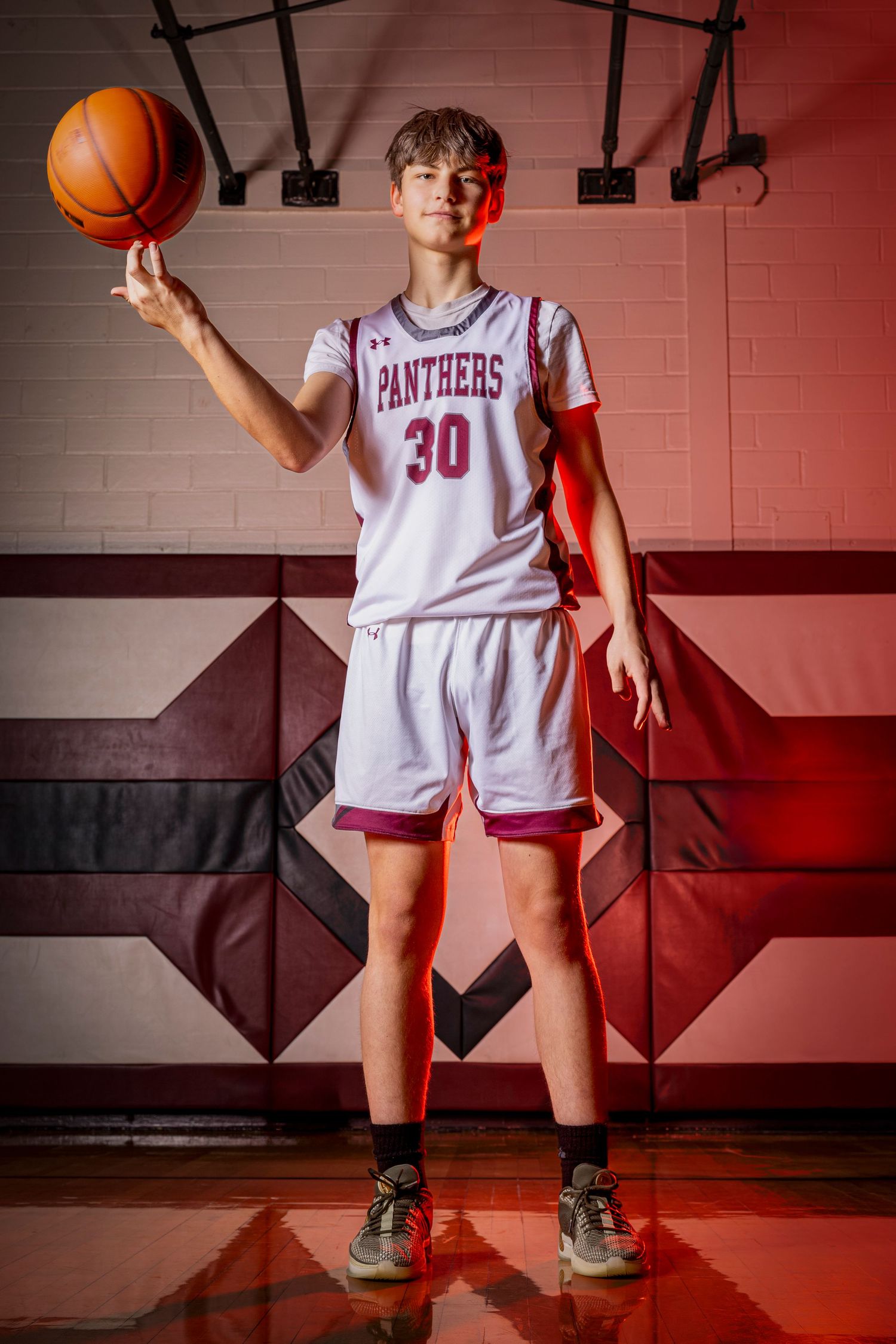 Individual basketball players pose confidently in uniform, capturing strength, focus, and determination in dynamic sports portraits.