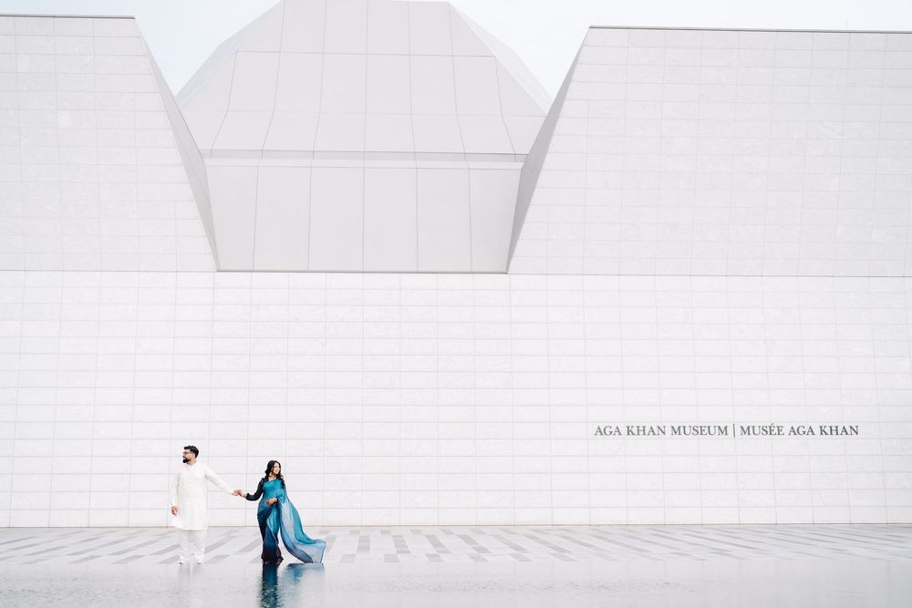 Couple walking outside the Aga Khan Museum in Toronto, featuring stunning white geometric architecture.