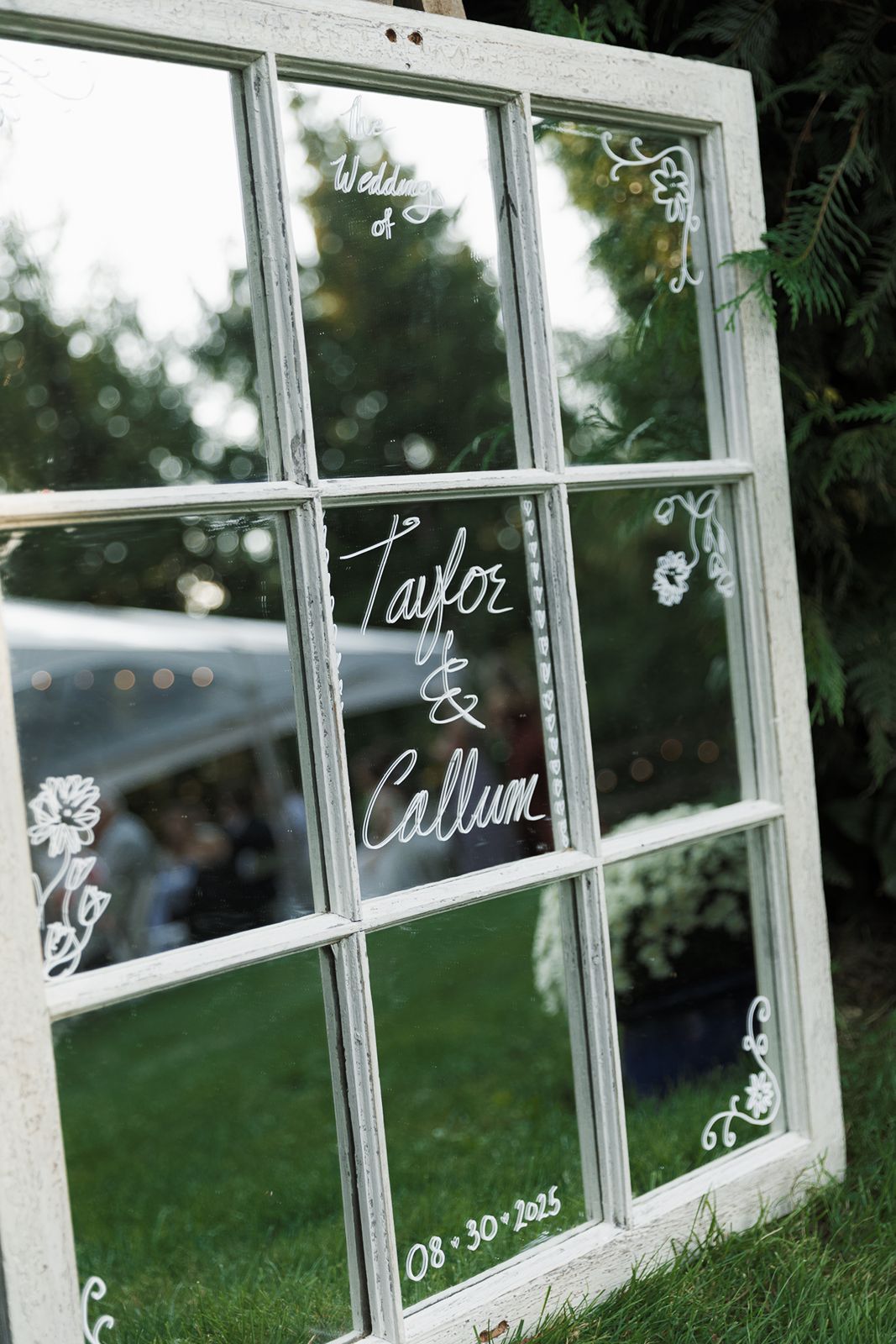 Vintage white window frame wedding sign reading Taylor and Callum 08-30-2025 outdoors.