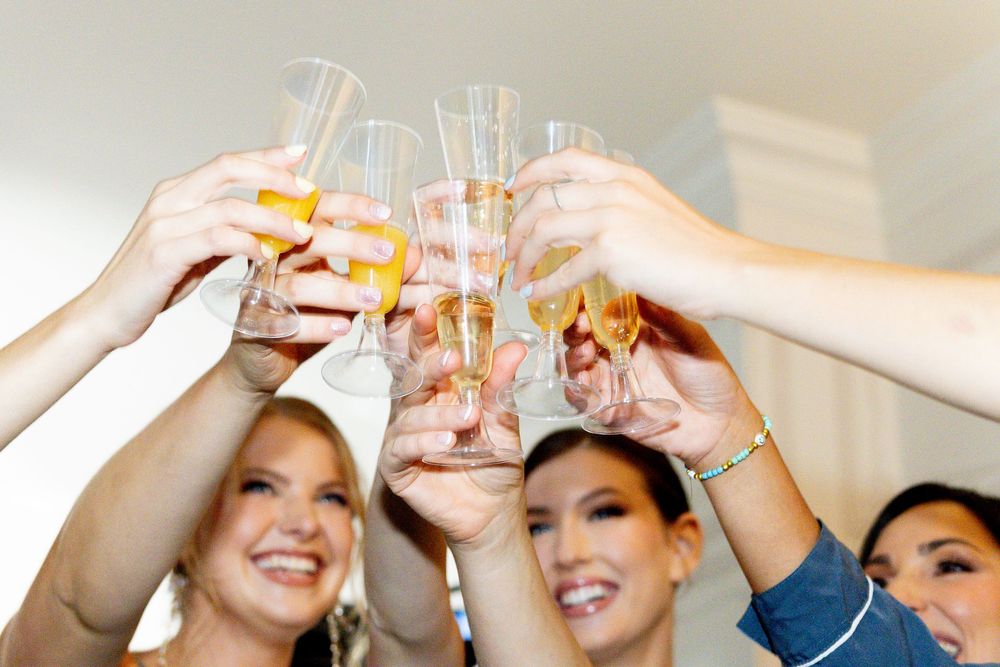 Group of smiling women toasting with champagne glasses at a celebration party.