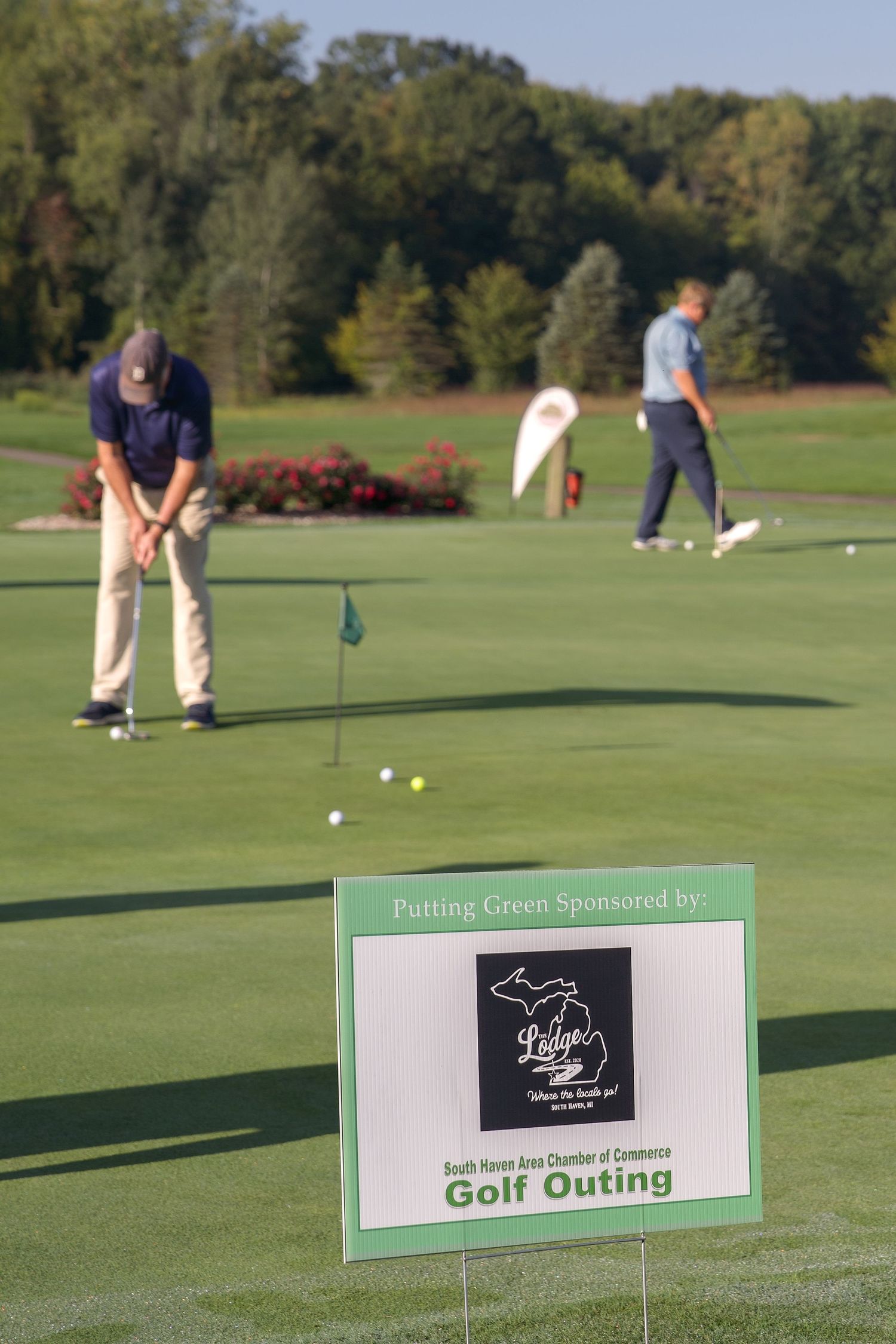 Golfers practice putting at South Haven Area Chamber of Commerce Golf Outing on a sunny day.