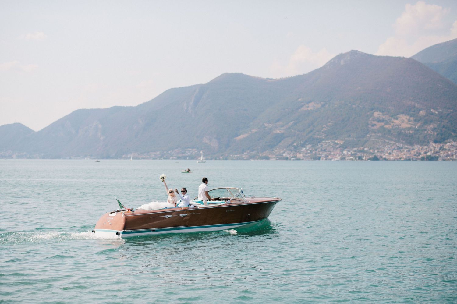 Bride and groom arriving on a Riva boat to their wedding at Lake Iseo, Italy