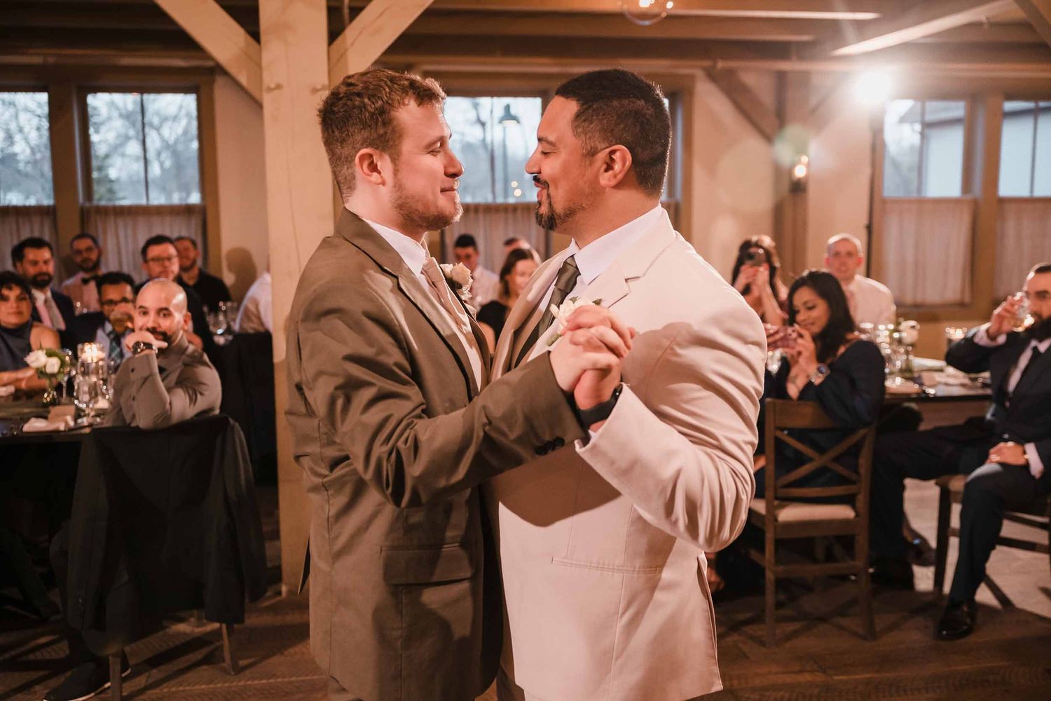Grooms sharing an intimate first dance surrounded by guests at Briar Barn Inn wedding reception