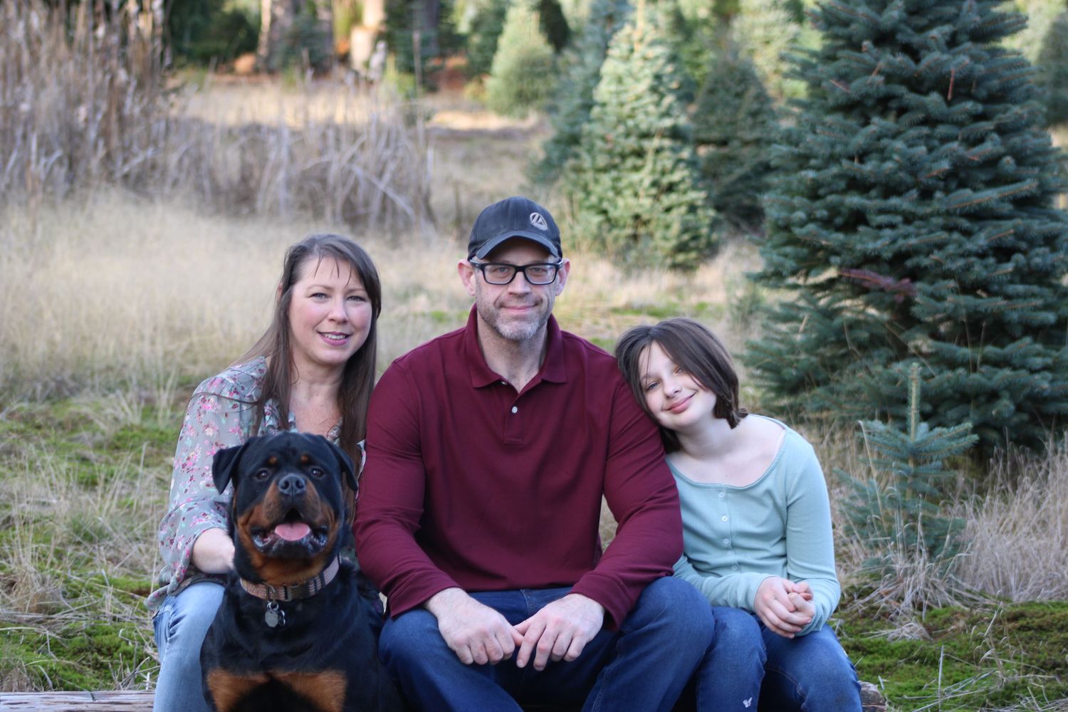 Outdoor family portrait in Arlington, Washington with parents, child, and dog, capturing a warm and natural moment.