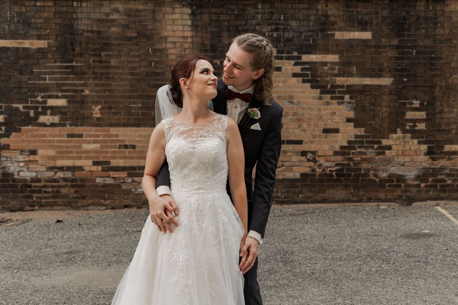 Natural wedding pohotography of a bride and groom standing together in an alleyway at The Walper Hotel in Downtown Kitchener, Ontario.